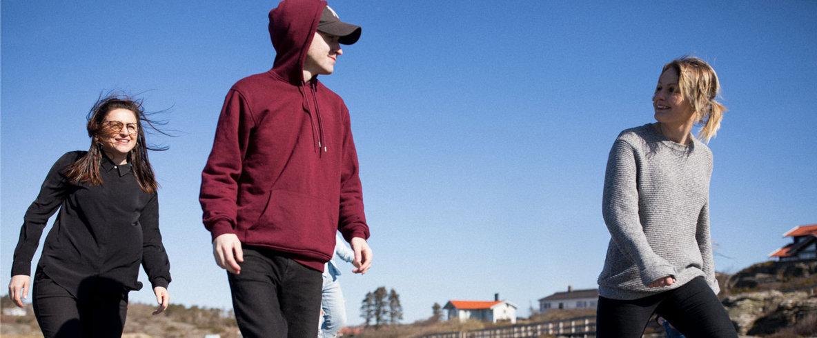 Ett gäng personer går på klipporna vid havet.