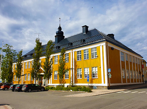 Bild: Sverigefinska folkhögskolan, en gul träbyggnad vid torget i Haparanda.